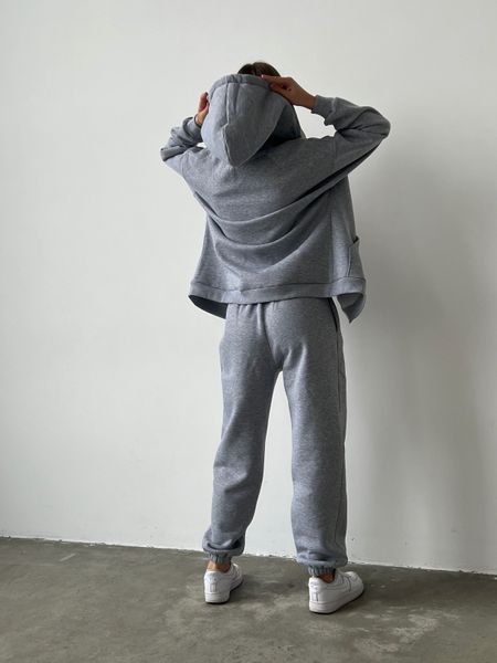 Warm women's sports suit with joggers and an elongated jacket with a zipper.