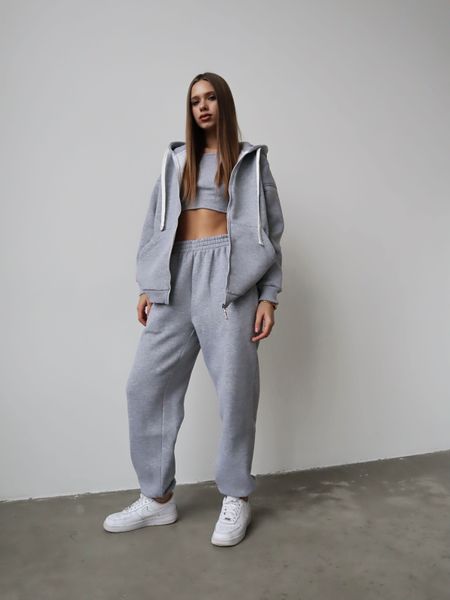 Warm women's sports suit with joggers and an elongated jacket with a zipper.