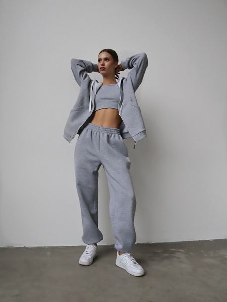 Warm women's sports suit with joggers and an elongated jacket with a zipper.