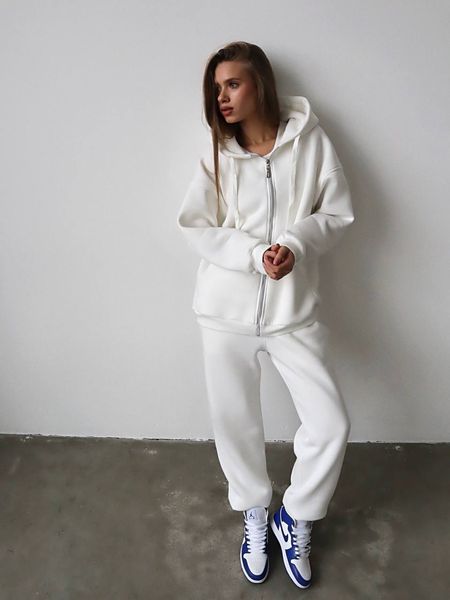 Warm women's sports suit with joggers and an elongated jacket with a zipper.